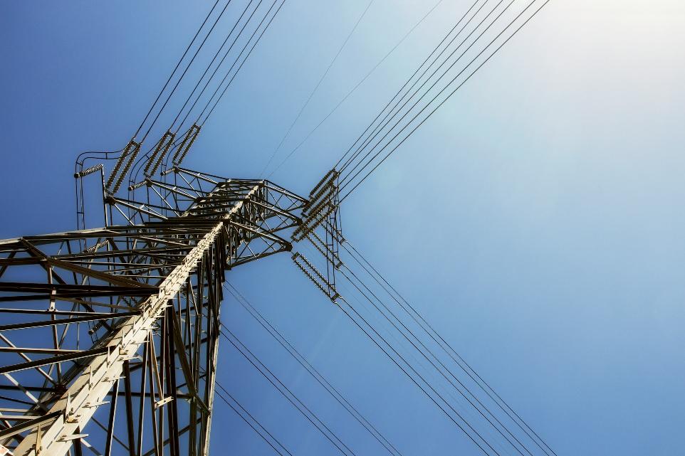 black electric post under blue sky during daytime